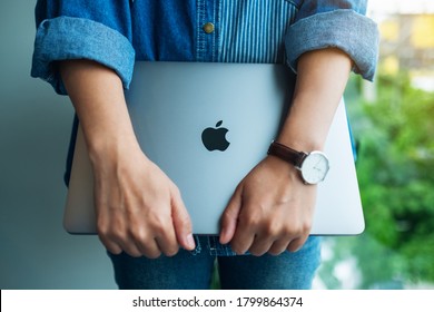 Aug 18th 2020 : A woman standing and holding an Apple MacBook Pro laptop computer , Chiang mai Thailand