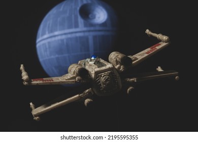 AUG 28 2022: Recreation Of A Scene From Star Wars A New Hope With A Rebel X Wing Fighter Approaching The Death Star - Disney Micro Galaxy Squadron Vehicle