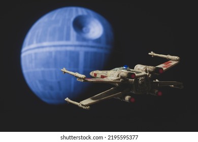 AUG 28 2022: Recreation Of A Scene From Star Wars A New Hope With A Rebel X Wing Fighter Approaching The Death Star - Disney Micro Galaxy Squadron Vehicle