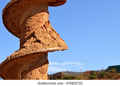 Auger Blade With Fresh Dirt And Subtle Landscape