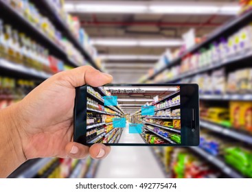 Augmented reality application for retail business concept. Hand holding smart phone with A/R application on screen to scanning sale alert in supermarket. Represent A/R application in real business. - Shutterstock ID 492775474