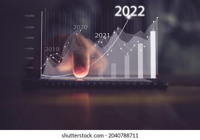 Augmented reality (AR) financial charts showing growing revenue In 2022 floating above digital screen smart phone, businesswoman having meeting about strategy for growth and success - Powered by Shutterstock