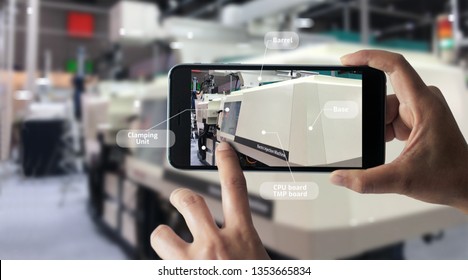 Augmented Reality Concept. AR. Industrial 4.0, Hand Of Engineer Holding Mobile Smart Phone Using Virtual AR To Check The Work Of Electric Machine On Smart Factory Background.