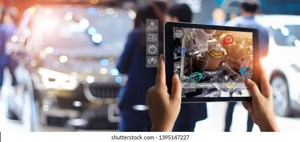 Augmented Reality Concept. AR. Industrial 4.0 , Hand Of Engineer Holding Tablet Using Virtual AR Service Application To Check The Work Of Electric Machine On Car Showroom Background