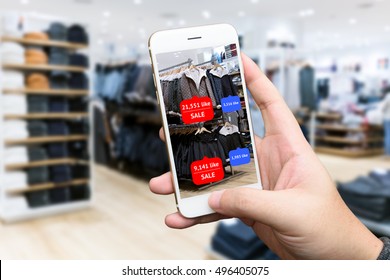 Augmented reality marketing concept. Hand holding smart phone use AR application to check number of social media like and sale price in retail fashion shop