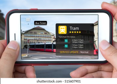 Augmented Reality Marketing Concept. Hand Holding Smart Phone Use AR Application To Check Schedule Timeline Of Tram And Buy Ticket. City And Tram Background