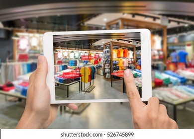 Augmented reality marketing concept. Hand holding digital tablet smart phone use AR application to check special sale price in retail fashion shop mall - Shutterstock ID 526745899