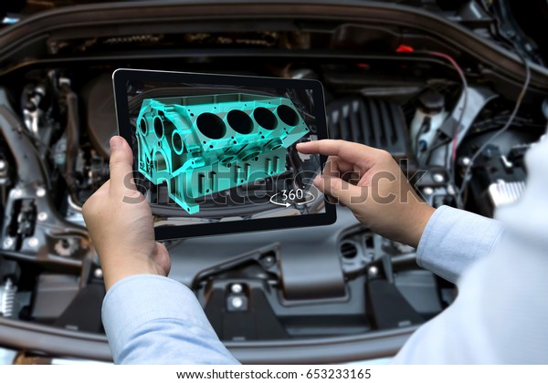 Augmented reality technology and engineering\
marketing concept. Hand holding tablet with AR service application\
to rotate 3d rendering of energy block 360 degrees with blur car\
engine room\
background