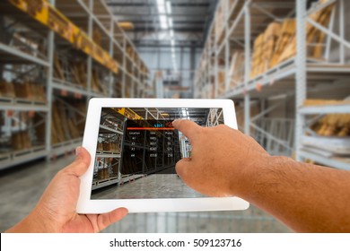 Augmented reality in warehouse and logistic concept. Hand hold and touching digital tablet with smart inventory application on screen in the warehouse. - Powered by Shutterstock - Get 15% off with code: PIKWIZARD15