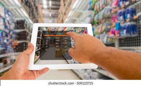 Augmented reality in warehouse and logistic concept. Hand hold and touching digital tablet with smart inventory application on screen in the warehouse.