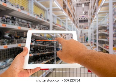 Augmented reality in warehouse and logistic concept. Hand hold and touching digital tablet with smart inventory application on screen in the warehouse.