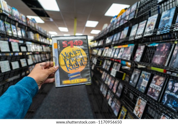 AUGUST 11 2018 - FAIRBANKS ALASKA: Female\
hand holds up a DVD rental case for sale at a closing Blockbuster\
Video store during its final days of\
business