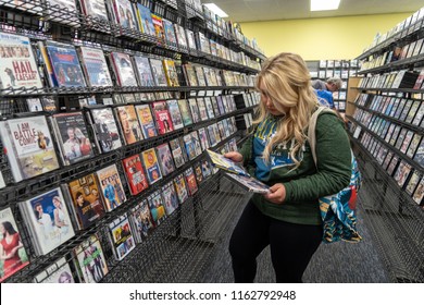 AUGUST 12 2018 - FAIRBANKS ALASKA: Blonde Woman Customer Shops For DVD Rentals Inside One Of The Last Remaining Blockbuster Video Rental Stores In The United States