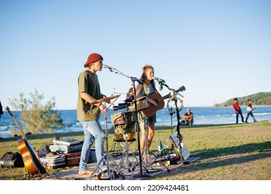 August 14, 2022: Byron Bay, New South Wales, Australia - Man And Woman Busking Outdoors In Sunny Weather