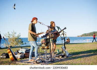 August 14, 2022: Byron Bay, New South Wales, Australia - Man And Woman Busking Outdoors In Sunny Weather