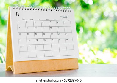 August 2021 Calendar desk for organizer to plan and reminder on wooden table on nature background.