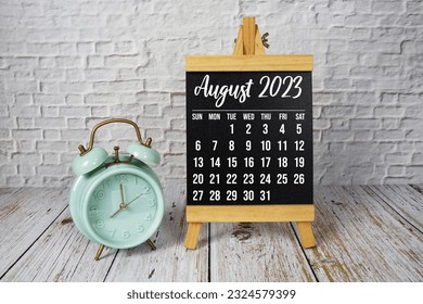 August 2023 monthly calendar on easel stand on wooden background