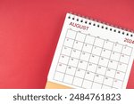 The August 2024 desk calendar on red color background.