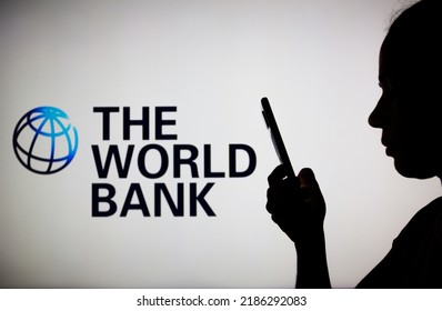 August 4, 2022, Brazil. In This Photo Illustration, A Woman's Silhouette Holds A Smartphone With The World Bank Logo In The Background