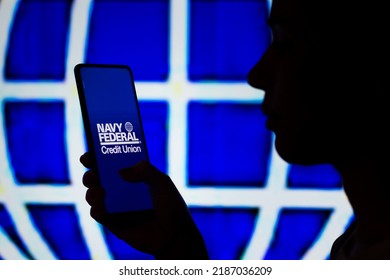 August 7, 2022, Brazil. In This Photo Illustration, A Woman's Silhouette Holds A Smartphone With The Navy Federal Credit Union Logo Displayed On The Screen And In The Background