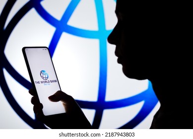 August 9, 2022, Brazil. In This Photo Illustration, A Woman's Silhouette Holds A Smartphone With The World Bank Logo Displayed On The Screen And In The Background