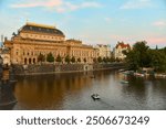 An august sunset rowing in the Vltava river in front of the National theatre during a peaceful summer evening in Prague, The Czech Republic