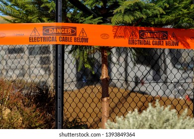 Augusta Marina, Margaret River Western Australia, 10/5/2019.
Red Plastic Banner Warning Of Electrical Cable In The Ground, With Star Picket Holding Up A Cyclone Fence.