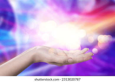 Aura phenomena. Woman with lights of energy coming out from her hand against color background, closeup