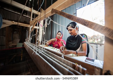 AURANGABAD, INDIA - 31 Dec 2016: People making colorful silk yarn fabric by Indian weaving loom, using the old Himroo and Paithani Weaving Technique. Silk Center at Aurangabad district, Maharashtra.