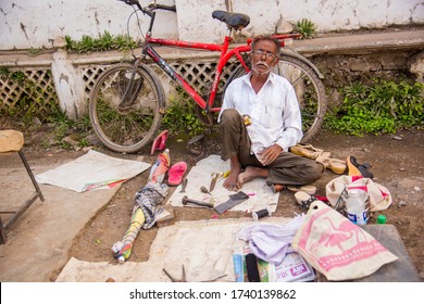 AURANGABAD, MAHARASHTRA, INDIA 23 NOVEMBER 2019 : A Boot Maker On His Road Side Street Shop And Smoking Bidi For Relax.