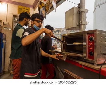 Aurangabad, Maharashtra, India-03-28-2021-Face Mask-wearing Boy Is Making Pizza In Pizza Oven In His Shop During Corona-COVID 19 Pandemic Spread, Post Lockdown.