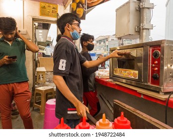 Aurangabad, Maharashtra,India-03-28-2021-Face Mask Wearing Boy Is Making Pizza In Pizza Oven In His Shop During Corona-COVID 19 Pandemic Spread, Post Lockdown.