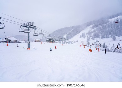 Auron, France - 01.01.2021: Downhill Skiing During A Heavy Snowfall. Professional Ski Instructors And Children On A Resort Slope In Mountains. Blurred Focus Background. High Quality Photo