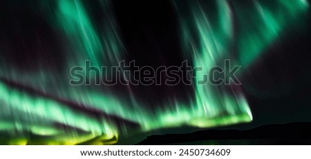 Aurora australis or Aurora borealis or Green northern lights sky above mountains. Night sky with polar lights. Night winter landscape with southern lights aurora against Real Natural black background.