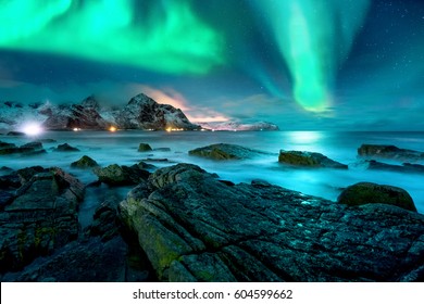 Aurora borealis above snowy islands of Lofoten - Shutterstock ID 604599662