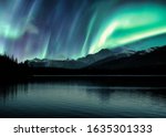 Aurora Borealis, Northern Lights over Canadian Rockies in forest on Pyramid lake at Jasper national park, Canada