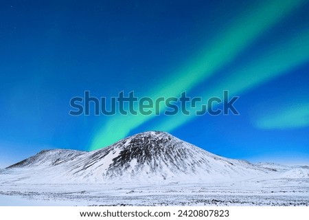 Aurora Borealis. Northern Lights over the mountains. A winter night landscape with bright lights in the sky. Landscape in the north in winter time. A popular place to travel.