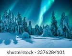 Aurora borealis. Northern lights in winter mountains. Wintry scene with glowing polar lights and snowy igloo. Christmas postcars