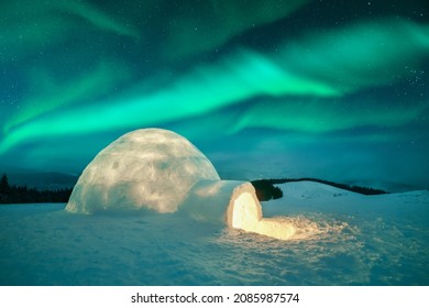 Aurora borealis. Northern lights in winter mountains. Wintry scene with glowing polar lights and snowy igloo. Landscape photography - Powered by Shutterstock