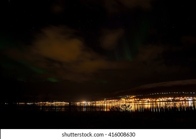 aurora borealis on autumn night sky over fjord and settlement in the arctic circle - Shutterstock ID 416008630