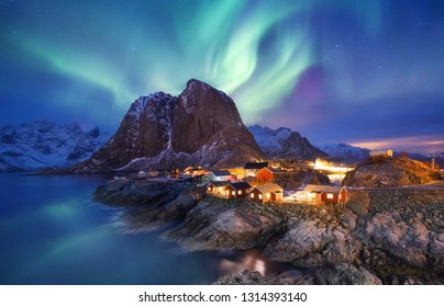Aurora borealis on the Lofoten islands, Norway. Green northern lights above ocean. Night sky with polar lights. Night winter landscape with aurora and reflection on the water surface. Norway-image - Shutterstock ID 1314393140