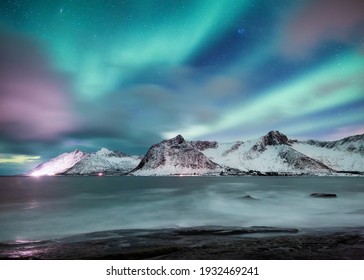 Aurora Borealis. Stars and northern light. Mountains and ocean. Night landscape. Long exposure shot. Senja island, Norway. Nature image