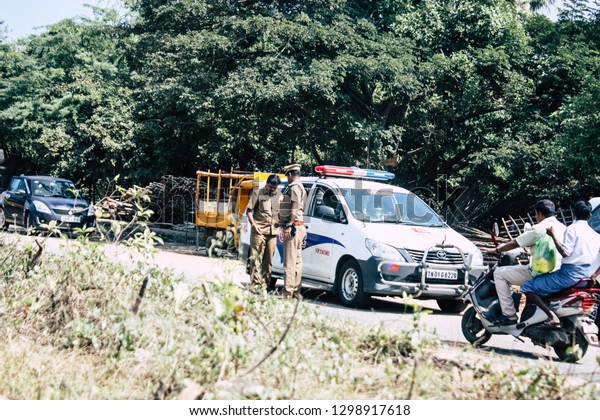 Auroville Tamil Nadu January 24, 2019 View of\
Indian police officers controlling cars at the road to Auroville in\
southern India in the\
afternoon