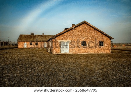 Auschwitz barracks under a round cloud