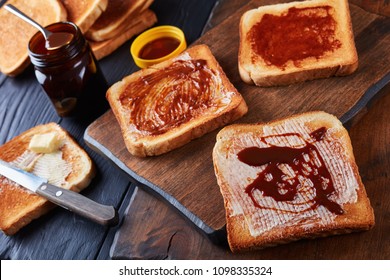 aussie savory toasts for breakfast with butter and vegemite- a thick Australian healthy food spread made from leftover brewers yeast extract with vegetables and spices, view from above, close-up