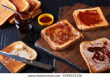 aussie savory toasts for breakfast with butter and marmite - a thick Australian healthy food spread made from leftover brewers yeast extract with vegetables and spices, view from above, close-up