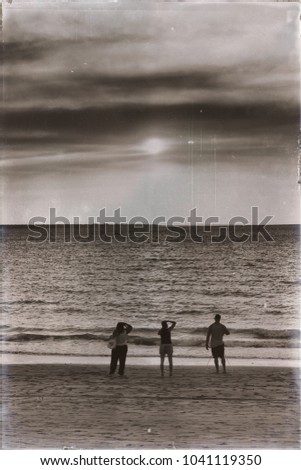 Similar – polaroid shows rear view of a woman in a stiff dress standing by the sea. north sea