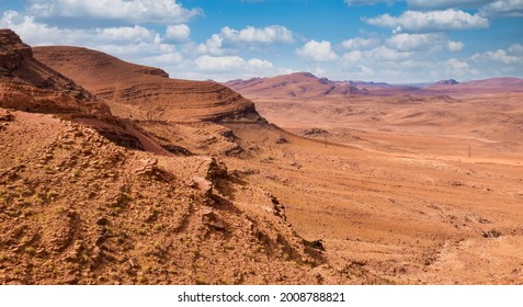 The austere beauty of the desolate Jbel Saghro mountain range, located in southern Morocco. A road is visible cut into the side of the rock on the left of the photo.