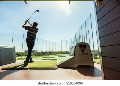 AUSTIN - CIRCA APRIL 2016: A man hits a golf ball at a Top Golf golfing complex.