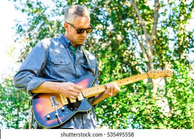 AUSTIN - CIRCA FEBRUARY 2016: A Middle Aged Man Plays The Electric Guitar As Part Of A Backyard Rock Band.